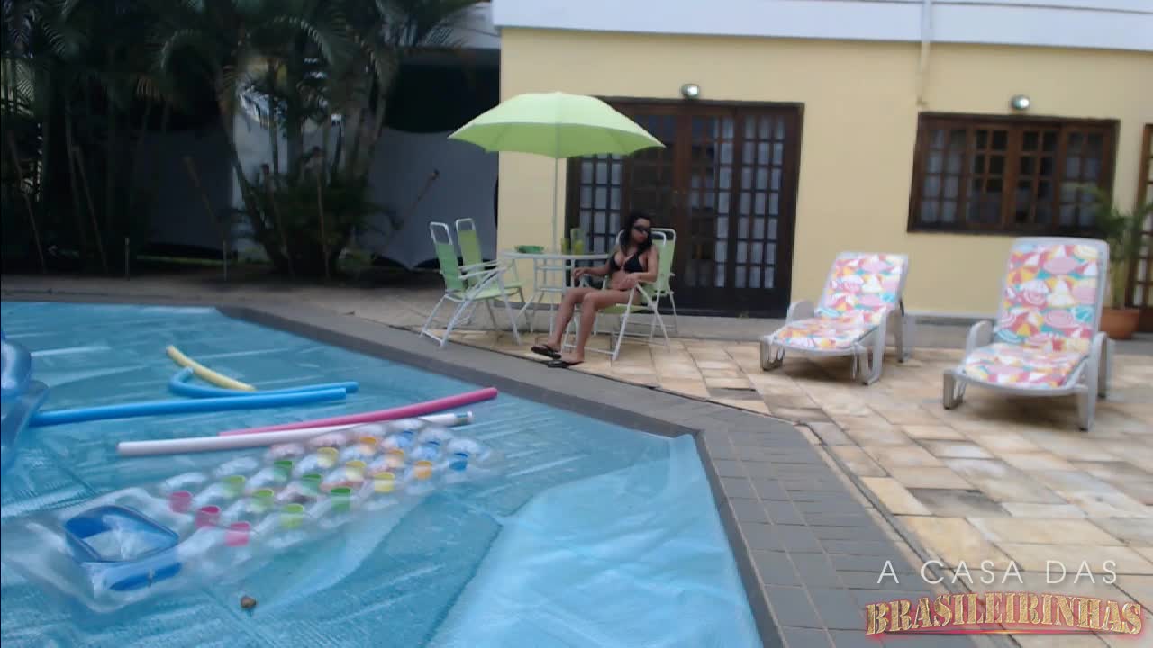 Jess relaxa na beira da piscina